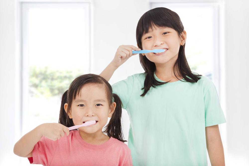 Two young girls brushing teeth in etobicoke