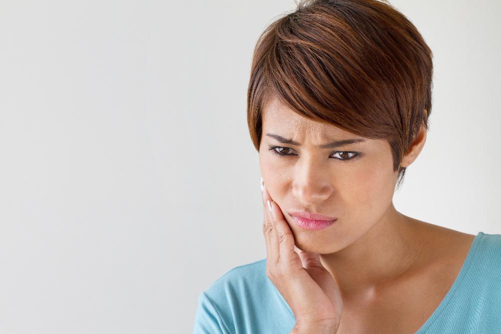 etobicoke Woman holding jaw from pain before tooth extraction