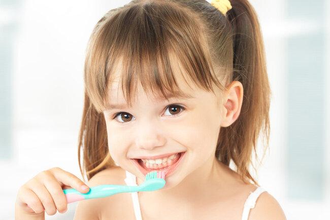 young girl brushing her teeth