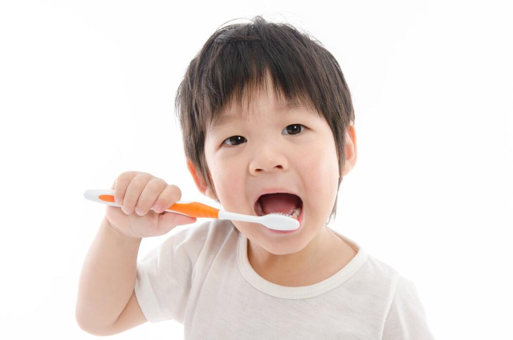 young child brushing teeth