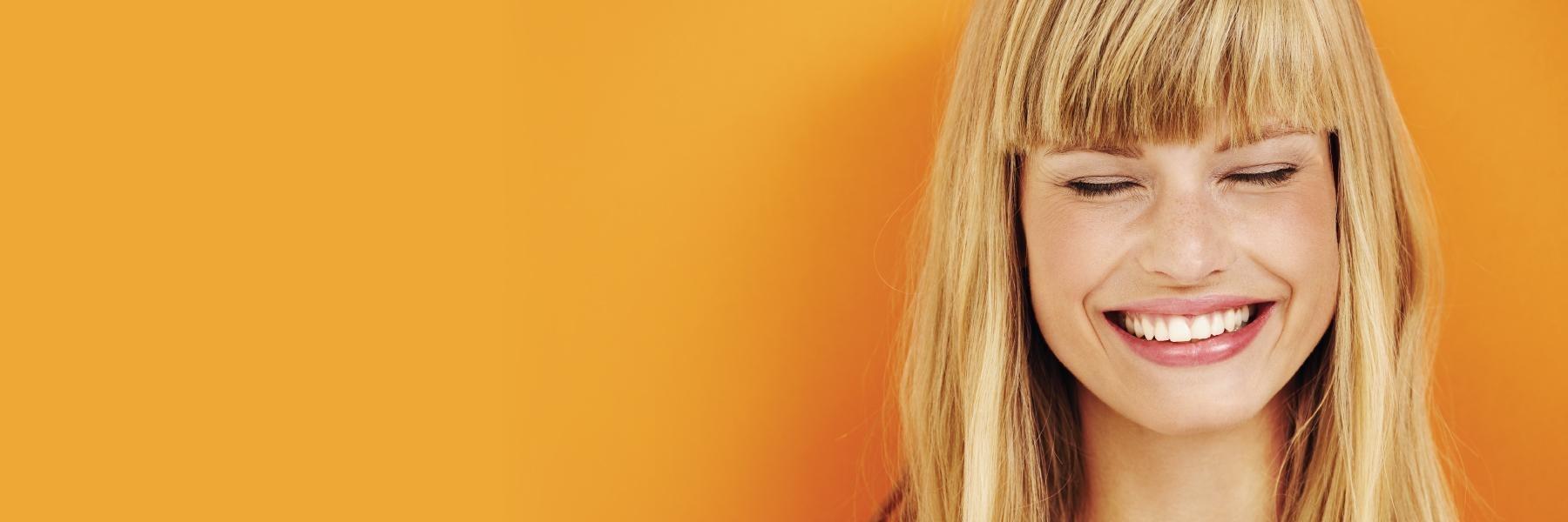 toronto woman smiling with orange background