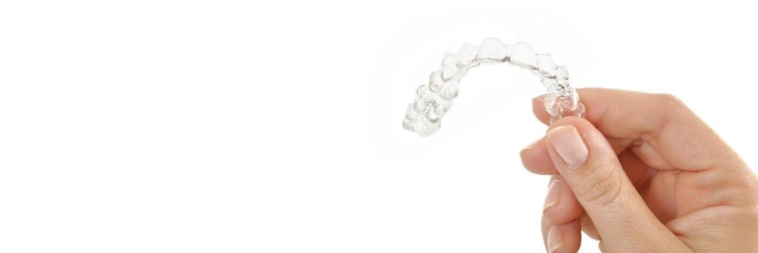 Female hand holding invisalign 