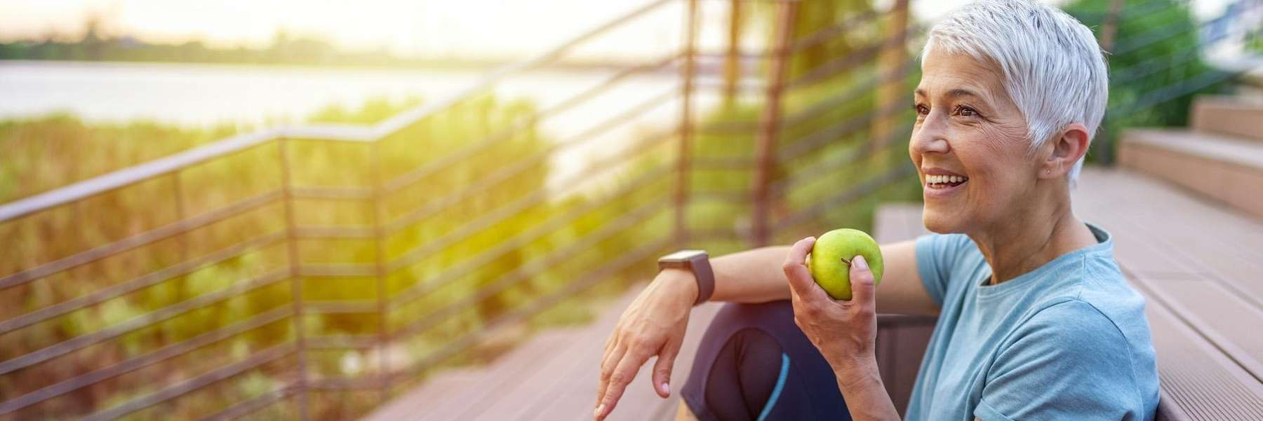 woman eating an apple while sitting on her deck