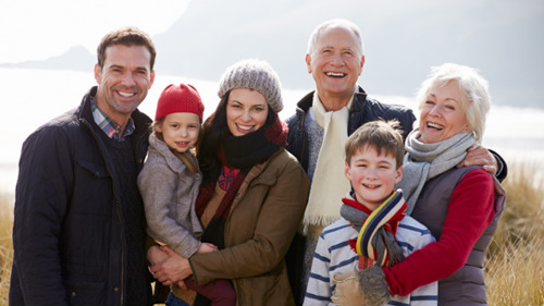 Smiling multi-generational family outdoors in winter clothing