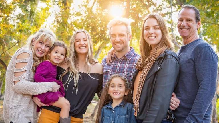 family smiling in the park