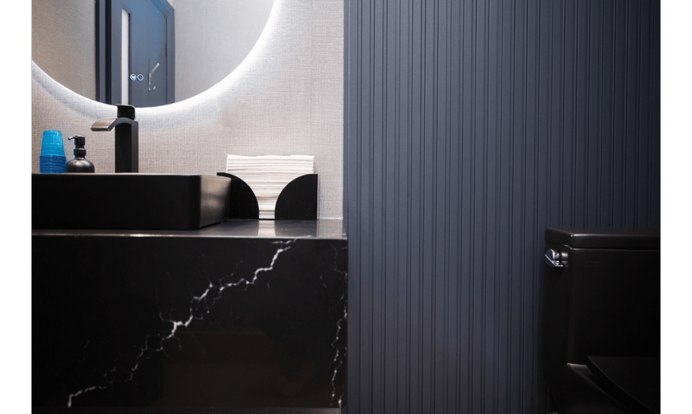 Modern washroom with black sink and illuminated mirror at Toronto Lakeshore Dental