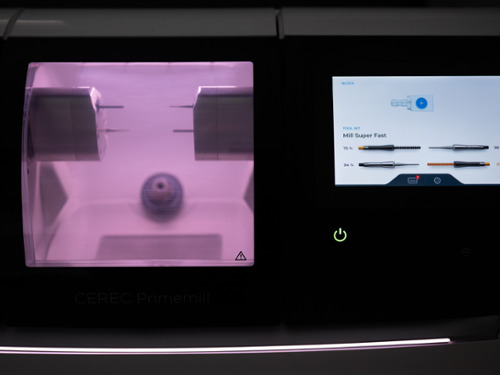 A specialized CEREC machine and computer monitor used to design and mill custom porcelain crowns in a single visit.