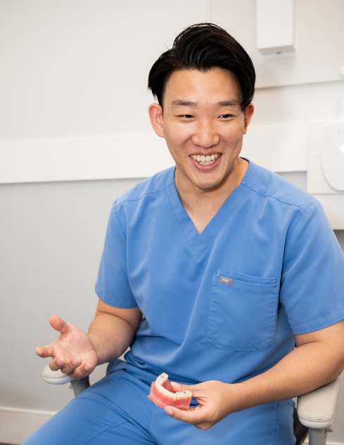 Toronto Lakeshore Dental | Dental patient smiling as a dentist gently checks her teeth during an exam